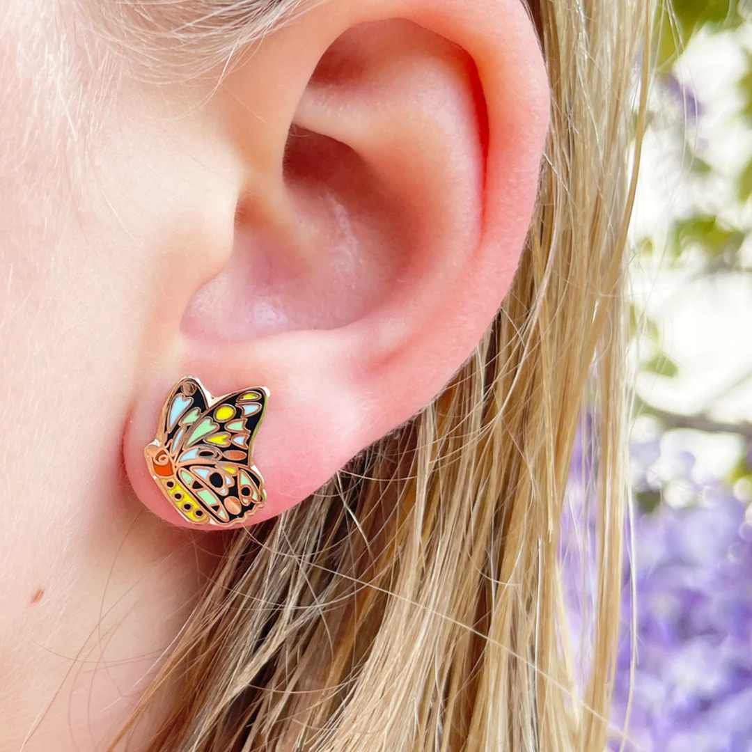 A picture of the Cairns Birdwing Butterly enamel stud earring being worn on the ear lobe.
