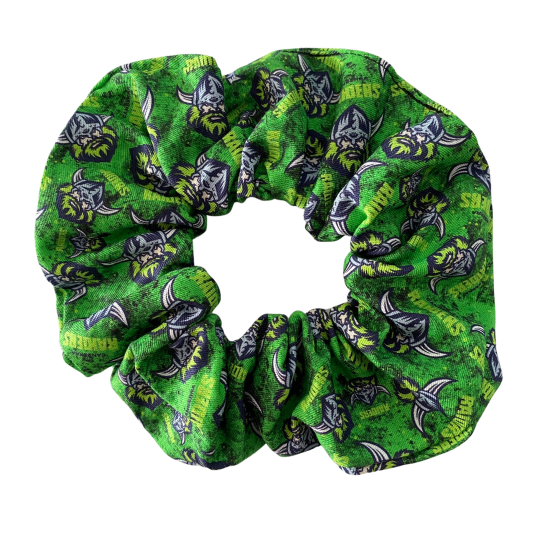 A scrunchie hair tie handmade with cotton woven fabric with images of the Canberra Raiders rugby league team.