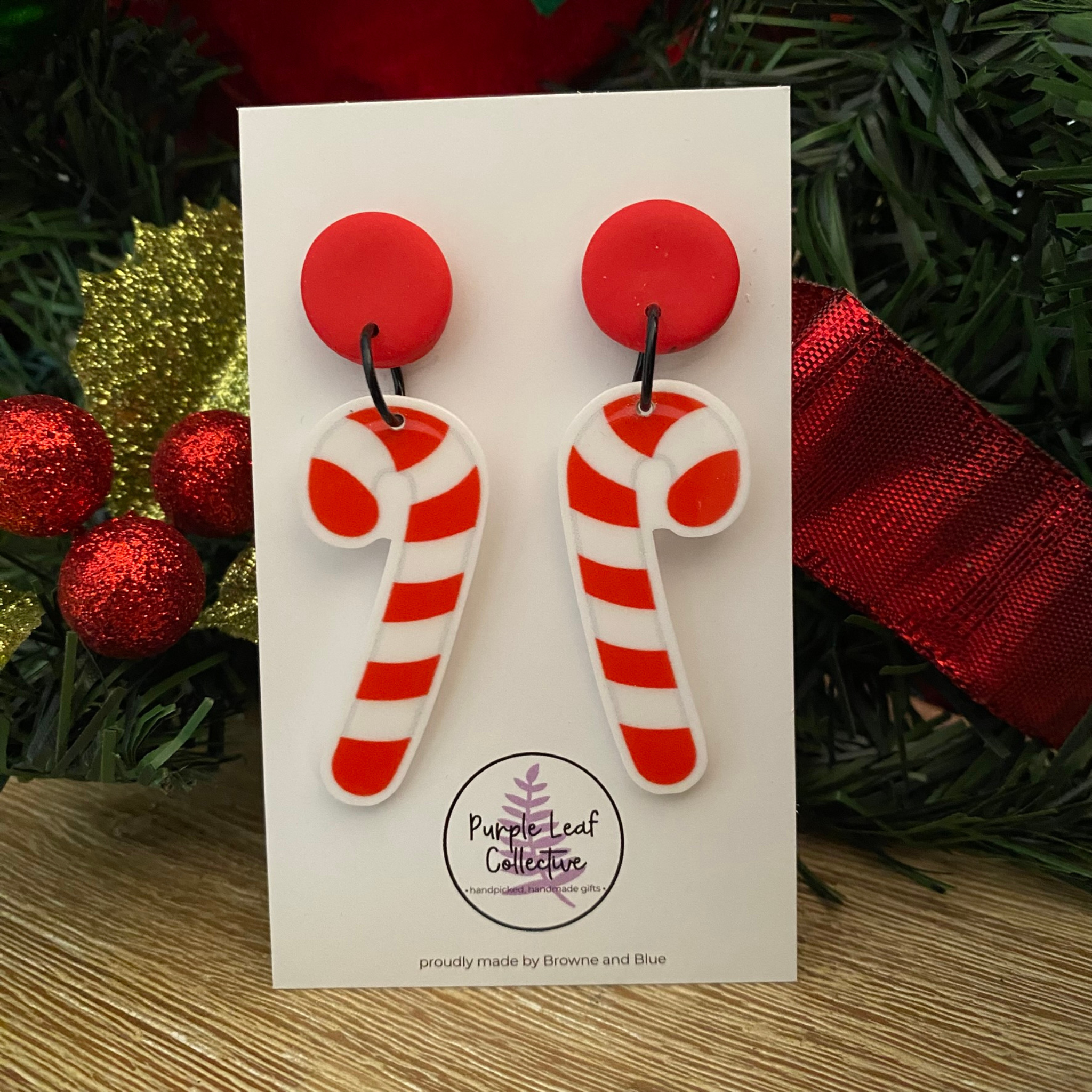 Candy cane earrings on a red stud topper on a white card.