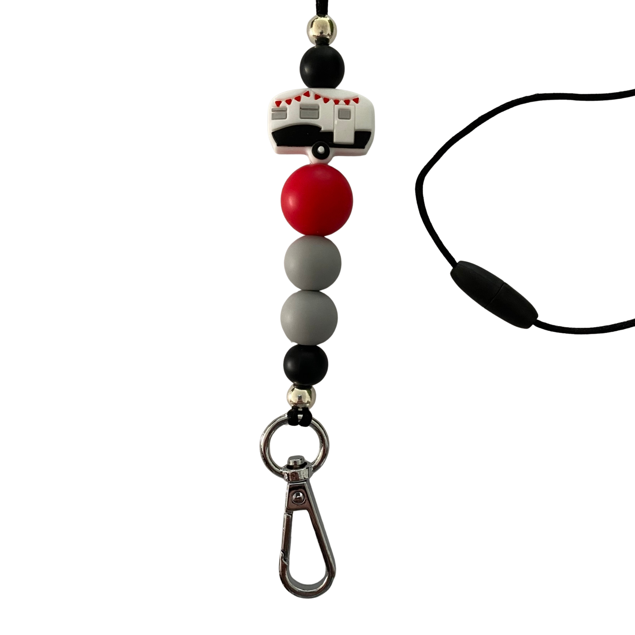Handmade silicone lanyard with black, grey, and red beads, featuring a white caravan charm with red bunting and a silver aluminium accent bead.