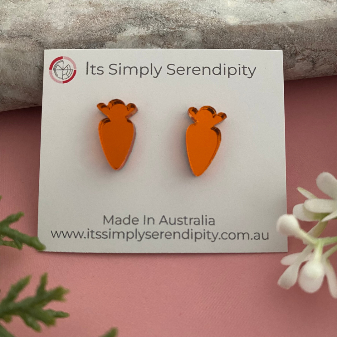 A pair of bright orange mirrored acrylic carrot stud earrings.