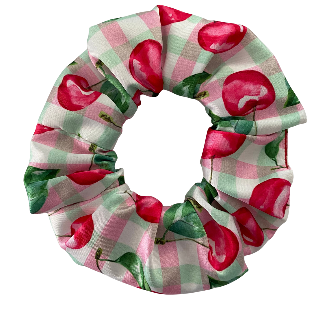 Scrunchie with cherry pattern on a checkered background.