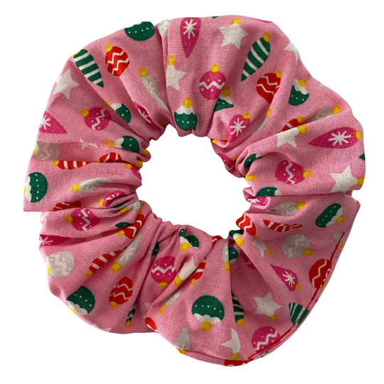 Pink scrunchie with colourful baubles patterns on a pink fabric.