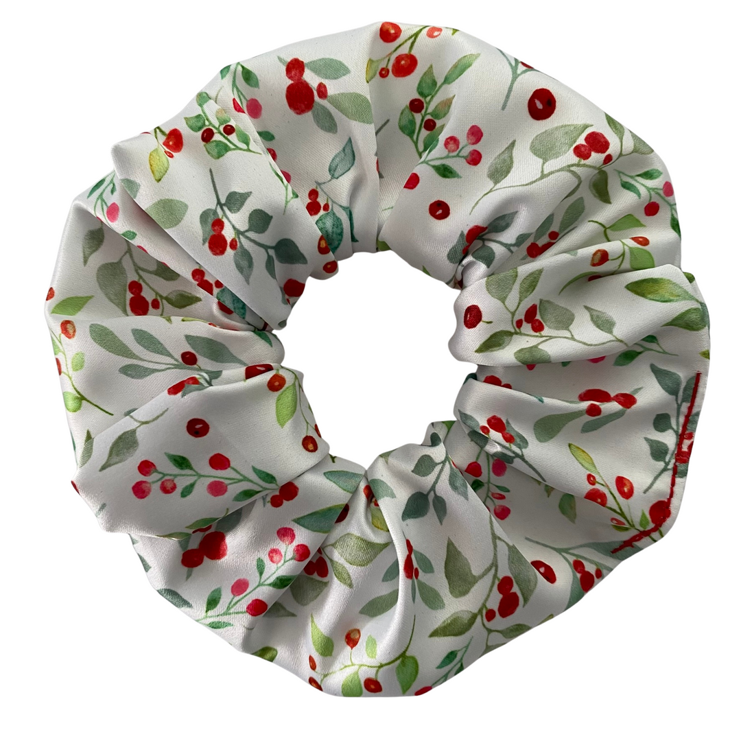 Scrunchie with red berries and green leaves on a white background.