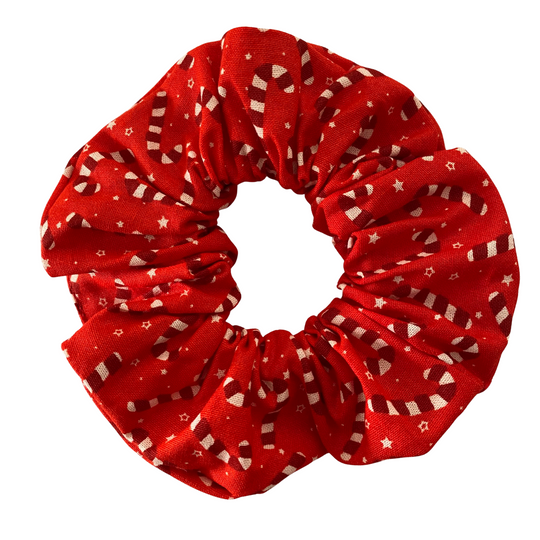 Red scrunchie with candy canes patterns on a white background.