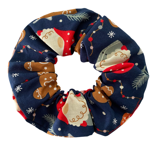 A dark blue scrunchie featuring festive images of gnomes and gingerbread man.