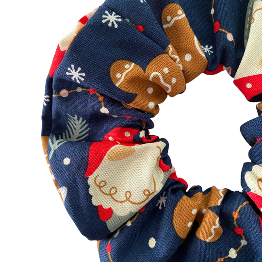 Festive images of gnomes and gingerbread men on a dark blue fabric.