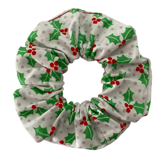 Christmas-themed scrunchie with holly leaves and berries on a white background.