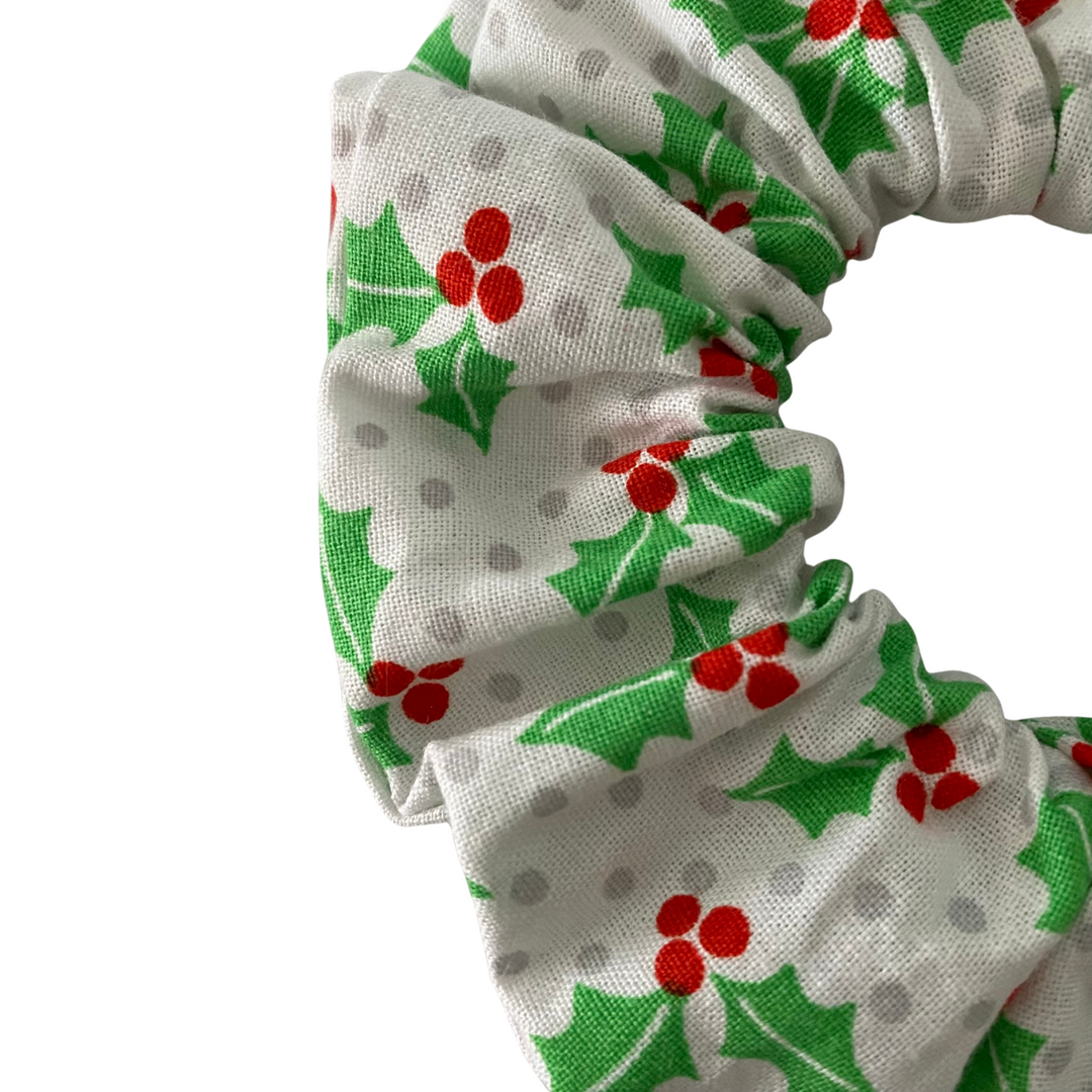 Scrunchie with holly and berry pattern on a white background.