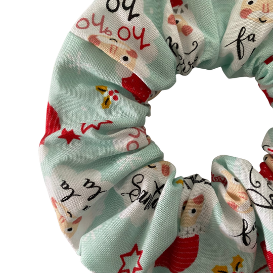 Scrunchie with festive design featuring Santa Claus on a light blue background.