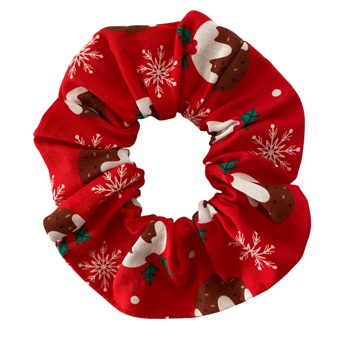 Red scrunchie with Christmas-themed designs on a white background.