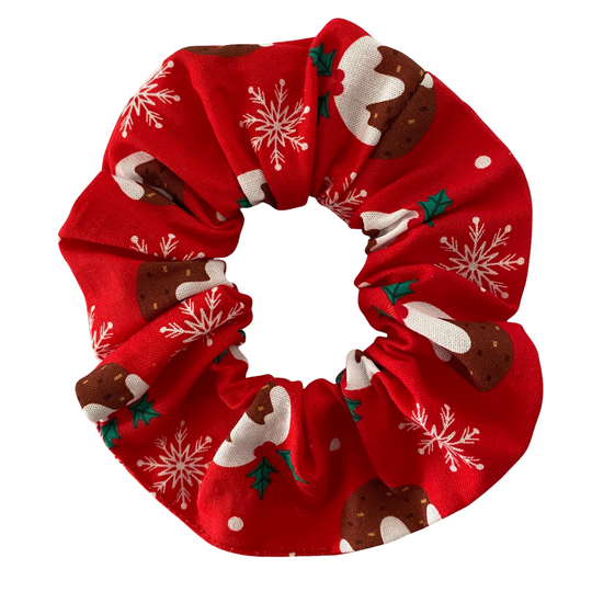Red scrunchie with Christmas pudding designs on a white background.
