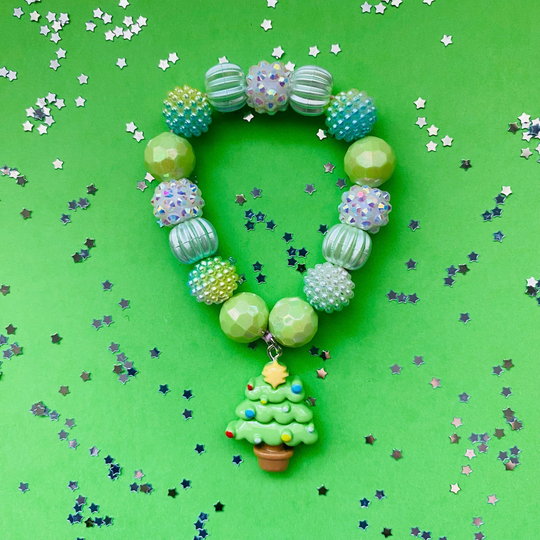 A beaded Christmas-themed bracelet with green, blue and iridescent beads, featuring a small green tree charm.