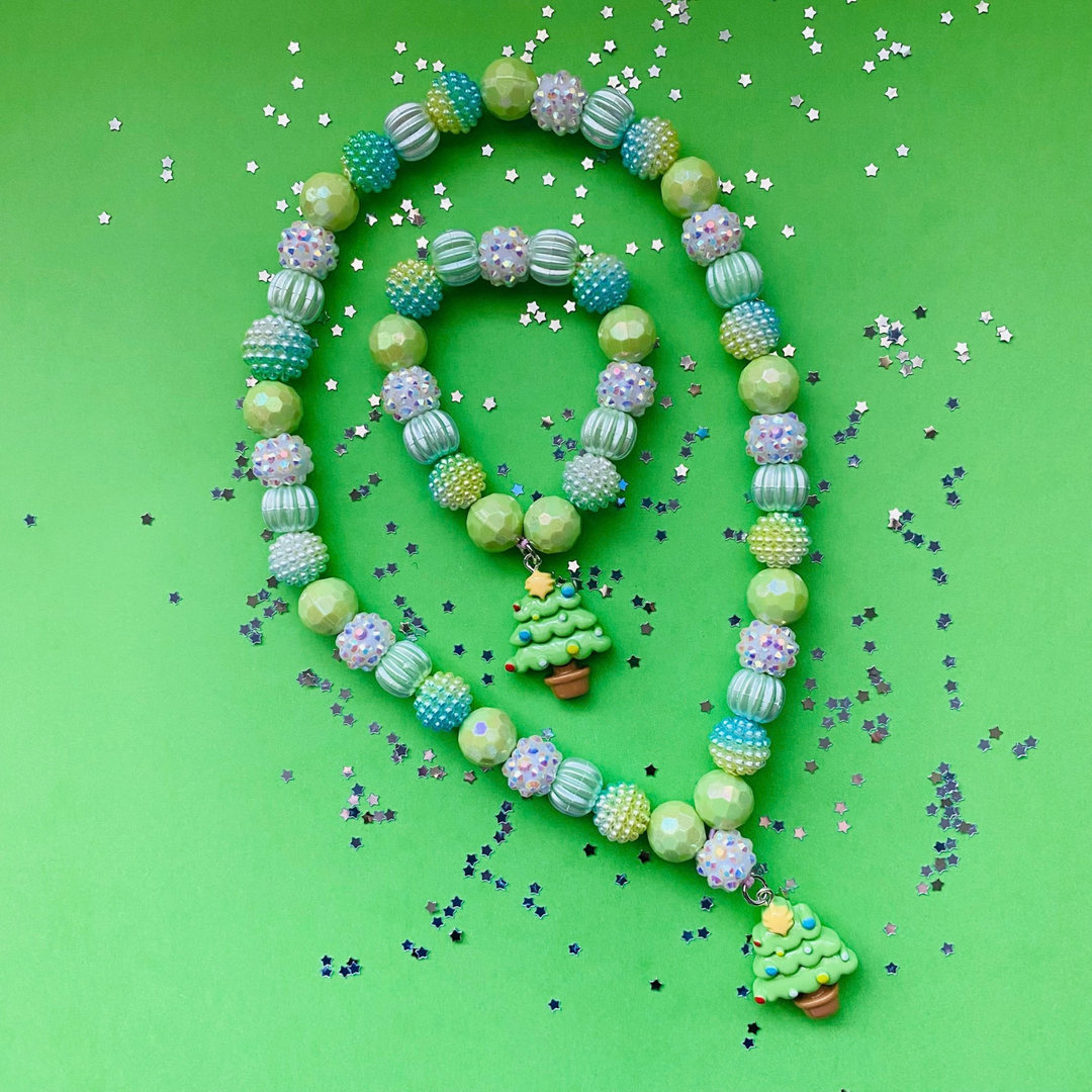 A beaded necklace and matching bracelet. Features pastel green, blue and white textured beads, with small Christmas tree charms.