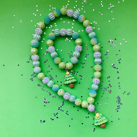 A beaded necklace and matching bracelet. Features pastel green, blue and white textured beads, with small Christmas tree charms.