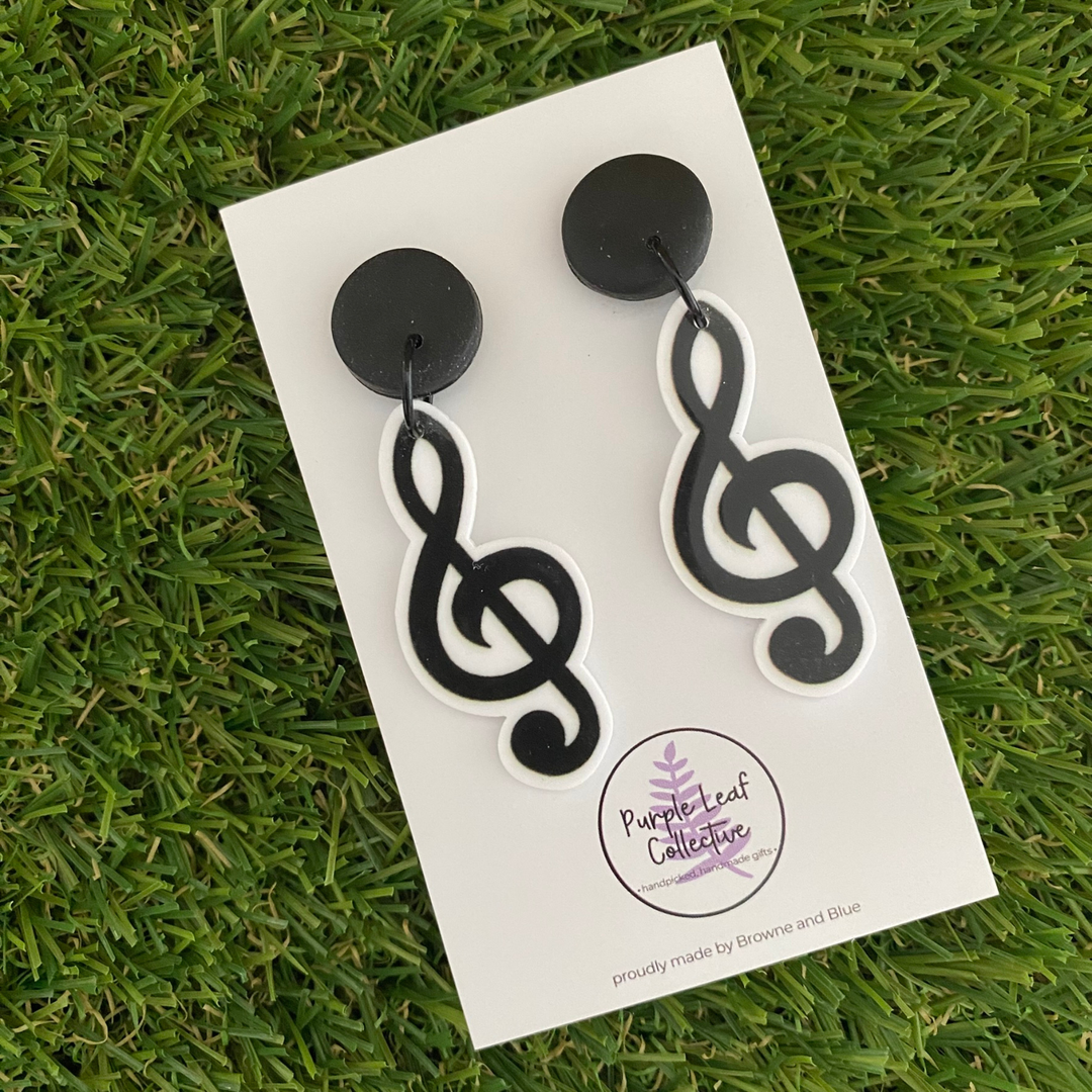 Black treble clef earrings set on black stud tops.