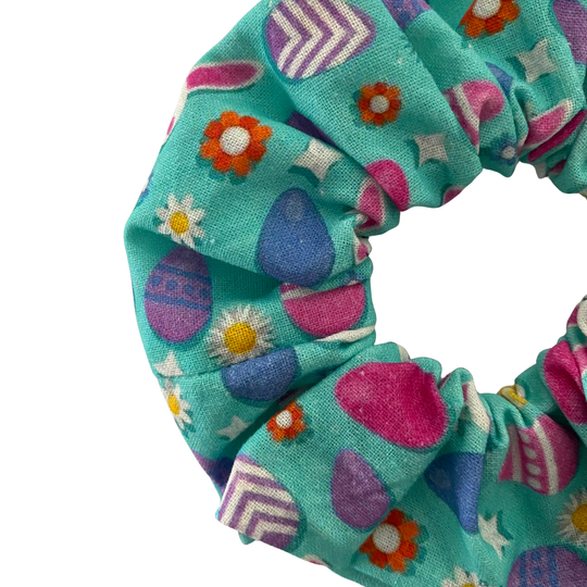 Blue fabric scrunchie with images of Easter bunnies and patterned Easter eggs.