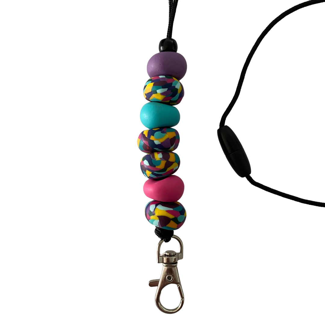 Handmade polymer clay lanyard with seven hand-rolled beads in purple, raspberry, turquoise and four multicoloured. Threaded on a nylon cord with a breakaway safety clasp and a silver-plated clip.