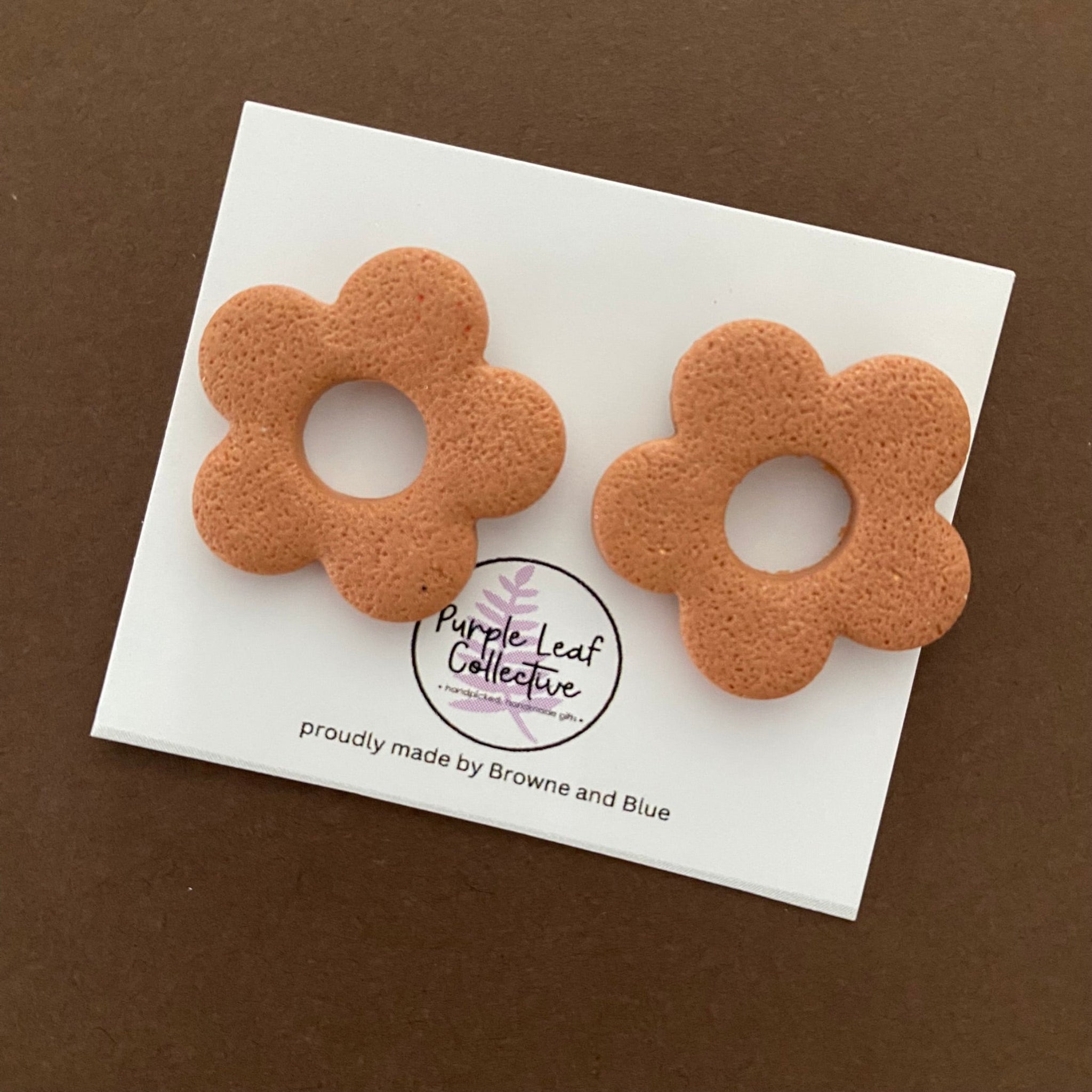 Drop stud earrings with five copper polymer clay flower petals, set on surgical steel posts for comfort and durability.