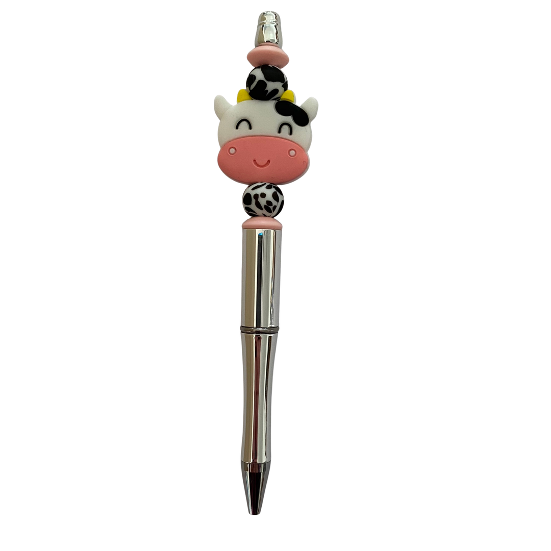 Pen with a cow head silicone bead on top on a white background.