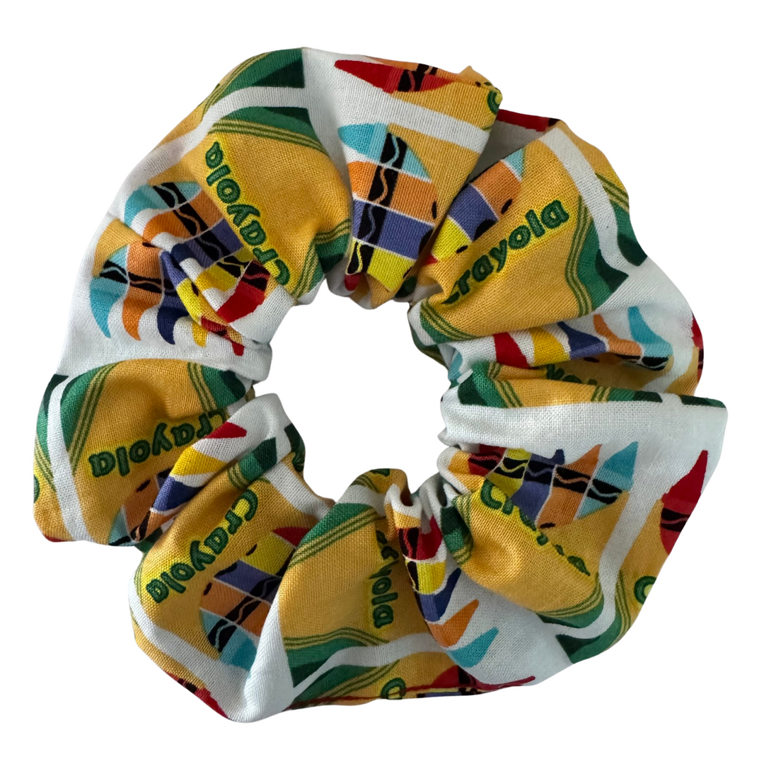 A scrunchie featuring packets of crayola crayons and the word crayola.
