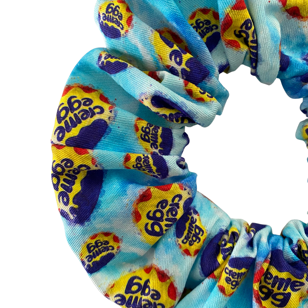 Cadbury Creme Egg images on a blue fabric scrunchie.