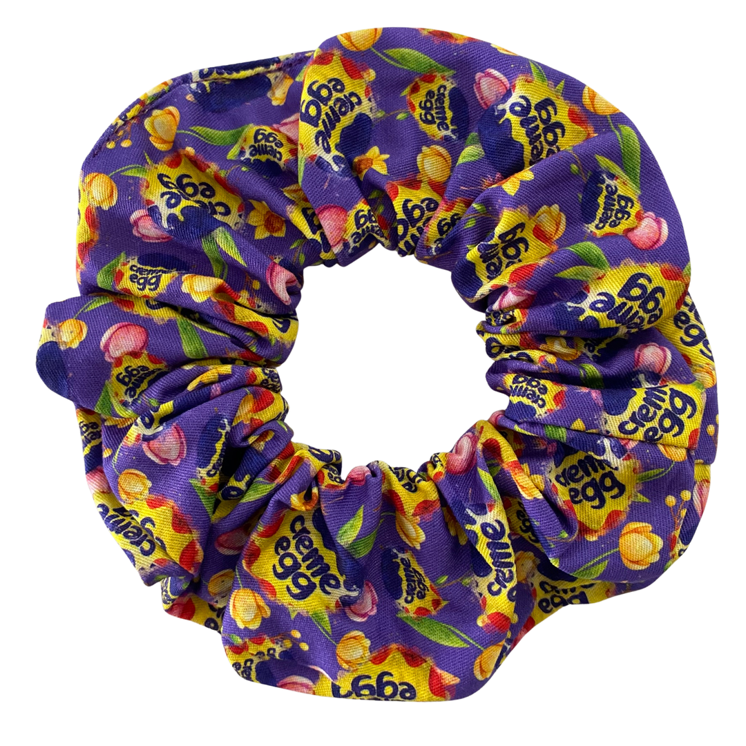 Colourful scrunchie with Cadbury Dairy Milk chocolate packaging design on a white background.