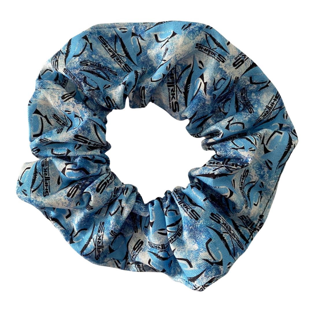 A scrunchie hair tie handmade with cotton woven fabric with images of the Cronulla-Sutherland Sharks rugby league team.