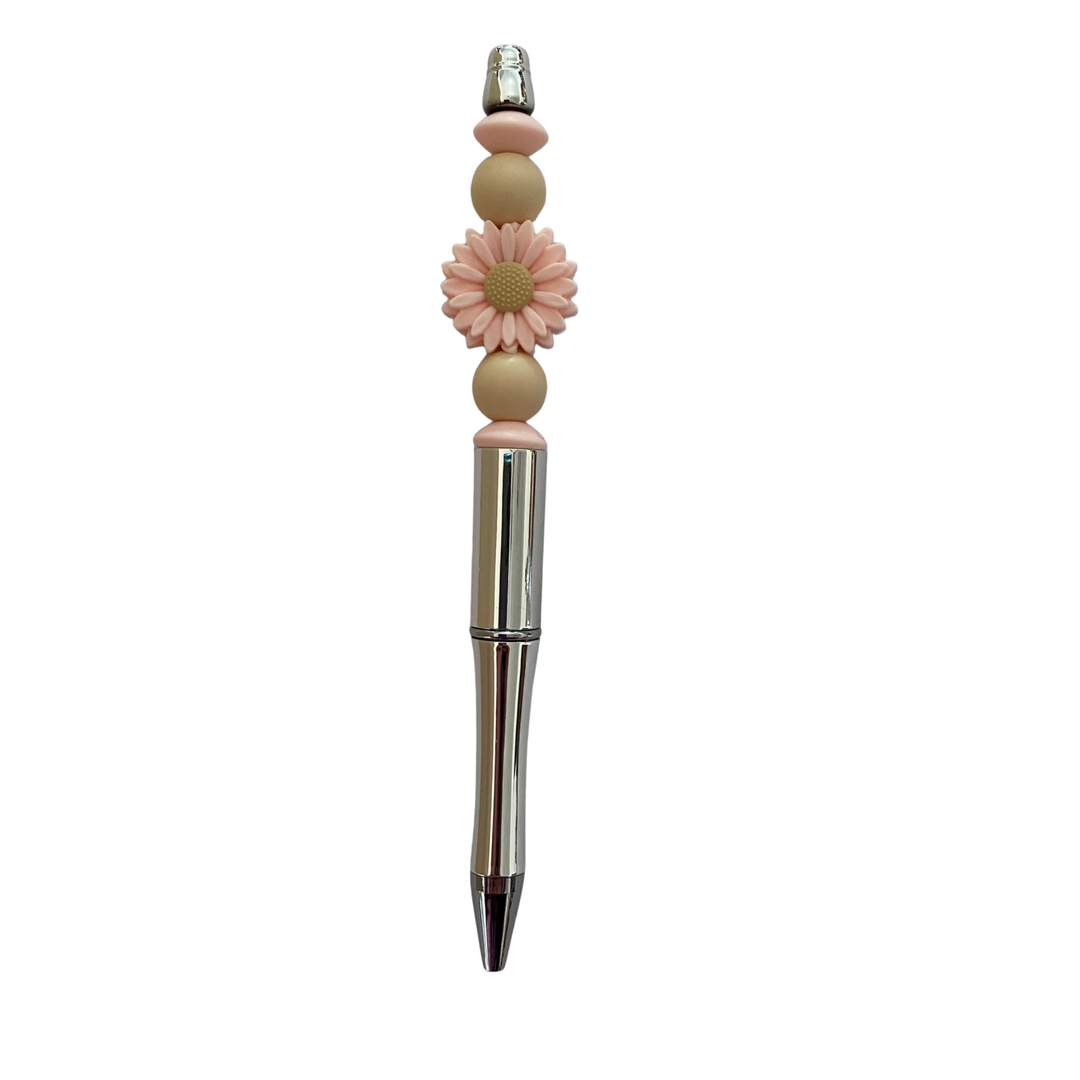 Decorative pen with beads and a baby pink flower on a white background.