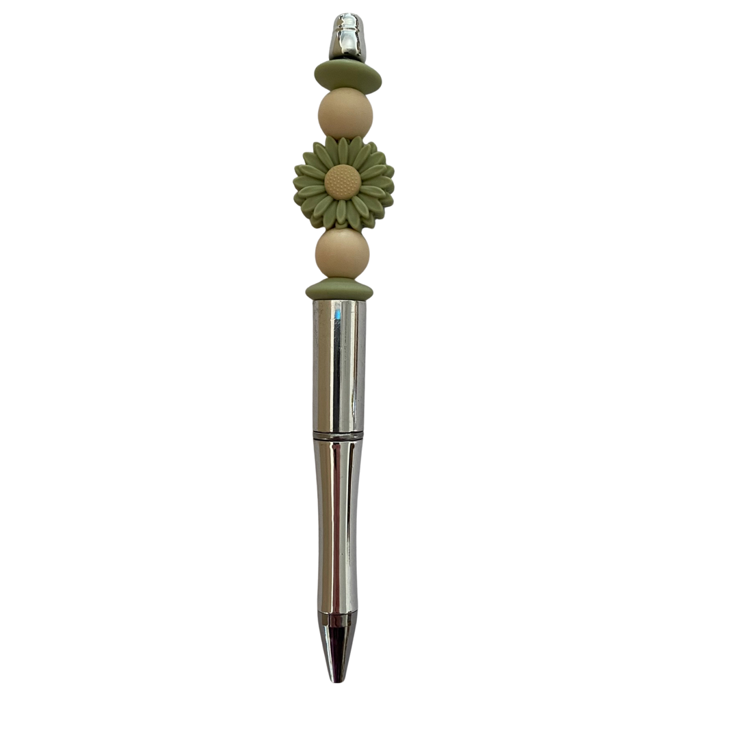 Decorative pen with green floral design on a white background.