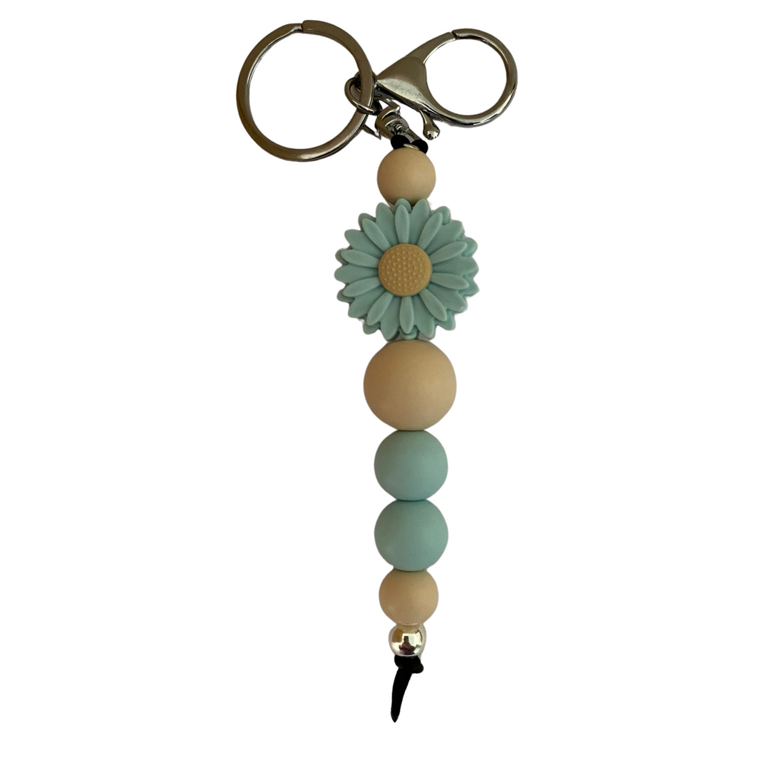 An 18cm keyring featuring a sea glass coloured daisy silicone bead and other round coloured silicone beads.