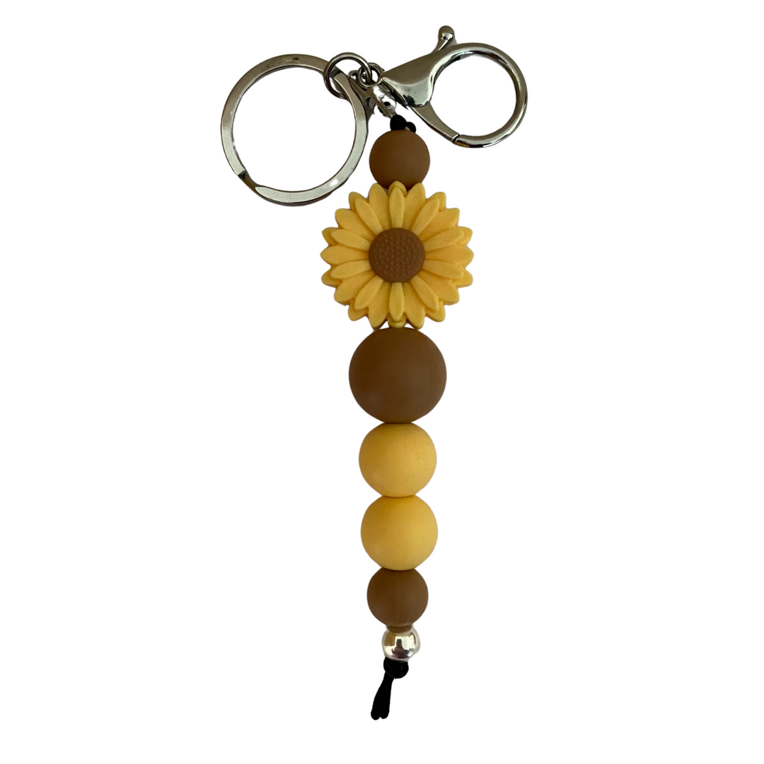 An 18cm keyring featuring a sunshine coloured daisy silicone bead and other round coloured silicone beads.
