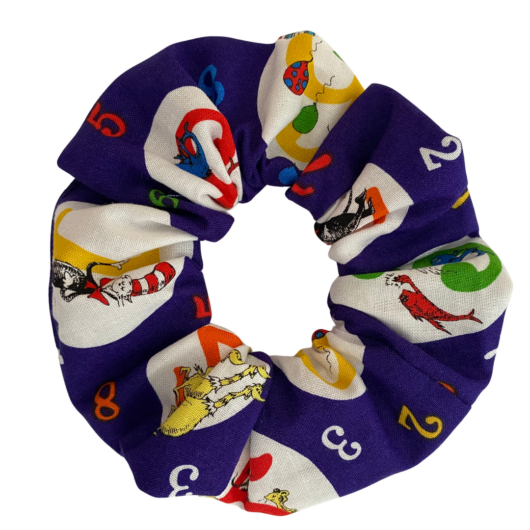 Dr Seuss scrunchie will illustrations of The Cat in the Hat, Thing 1 and Thing 2, Blue Fish, Red Fish and more. Featuring durable braided elastic for secure styling.