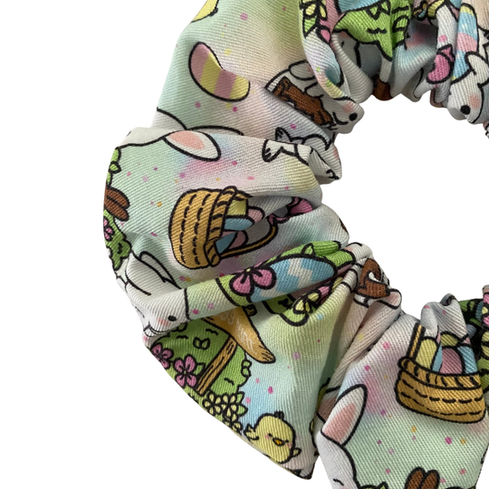 Scrunchie with Easter-themed design featuring bunnies, eggs and baskets on a white background.