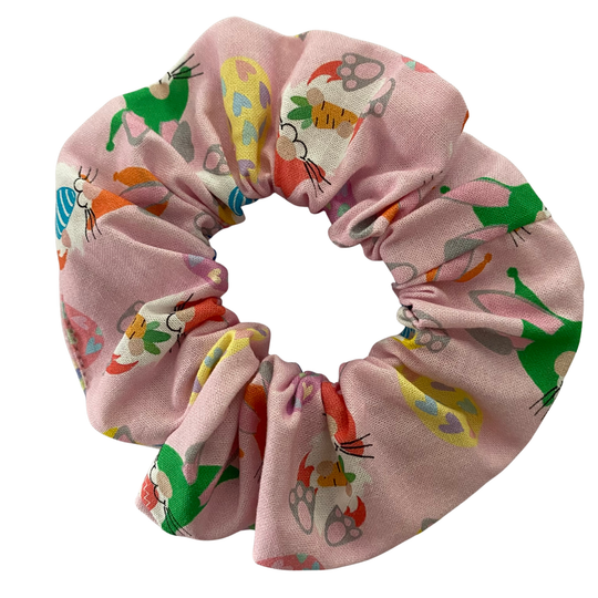 Scrunchie with images of Easter Gnomes and patterned Easter eggs on a pink fabric.