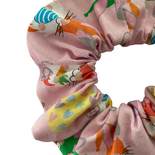 Pink fabric scrunchie with images of Easter Gnomes and patterned Easter eggs.