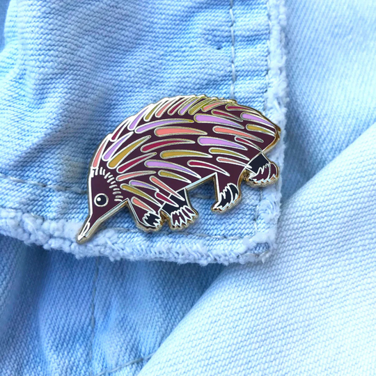 A picture of the Echidna Enamel Pin pinned to a denim jacket.