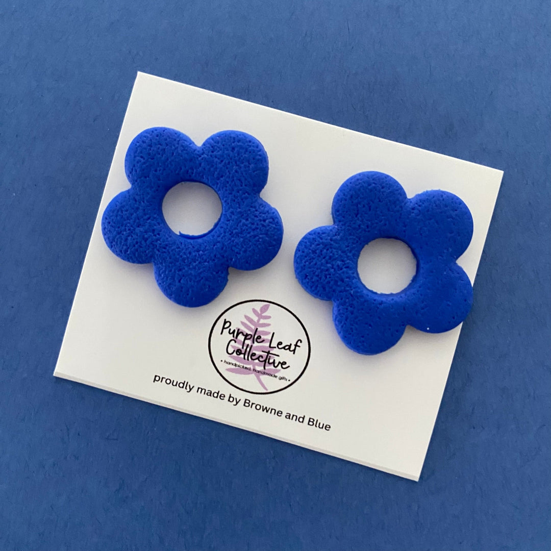 Drop stud earrings with five electric blue polymer clay flower petals, set on surgical steel posts for comfort and durability.