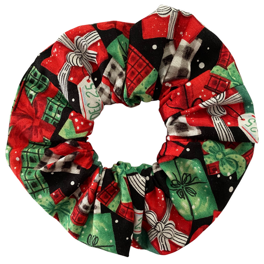 Christmas red and green gifts on a black fabric scrunchie on a white background.