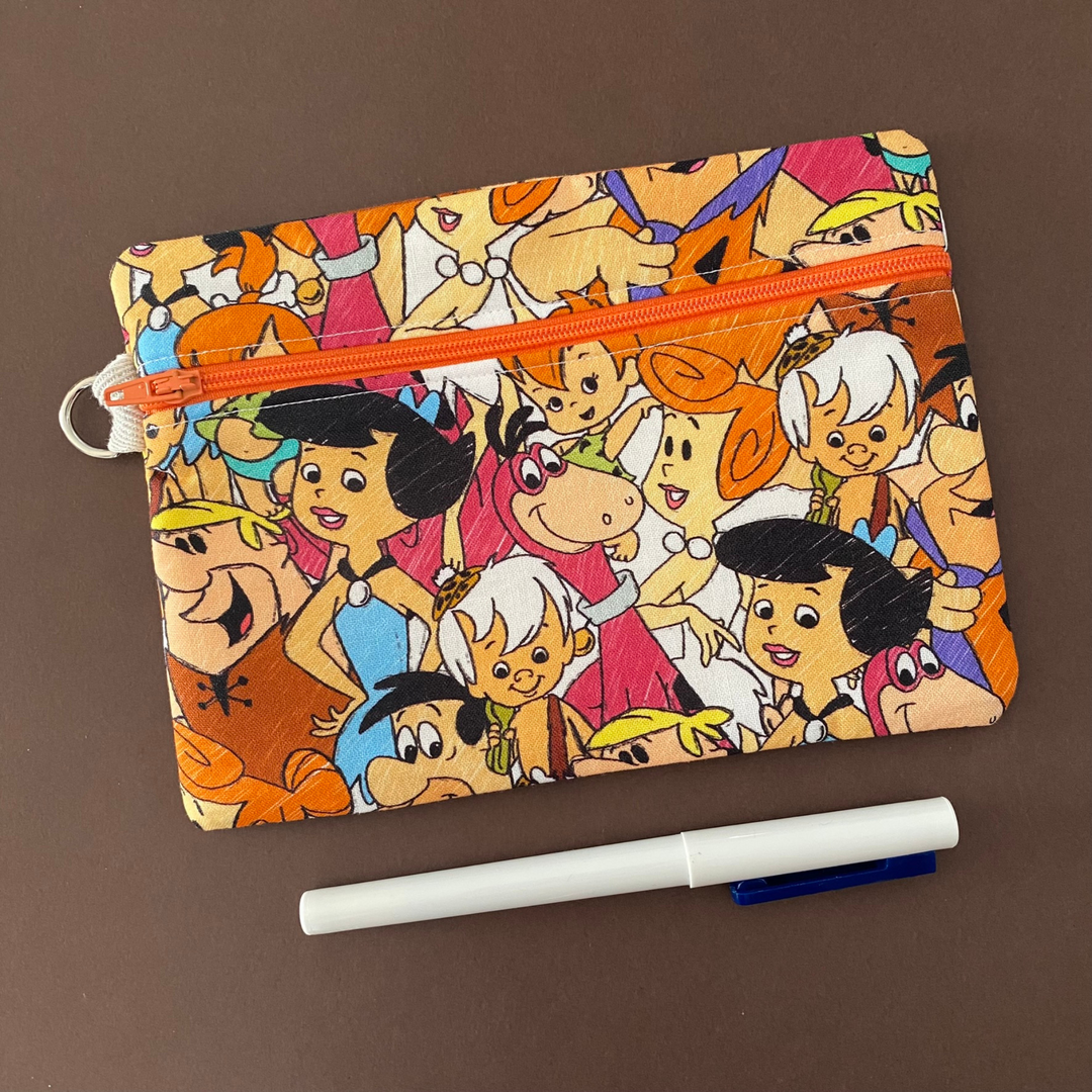 Zipper pouch with images of Flintstones characters. Planner accessory for school or work. Perfect for small essentials.