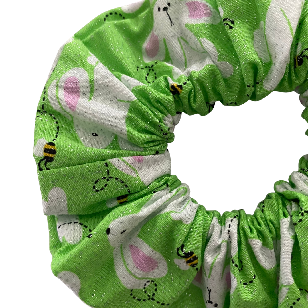 Green scrunchie with bunny and bee pattern on a white background.