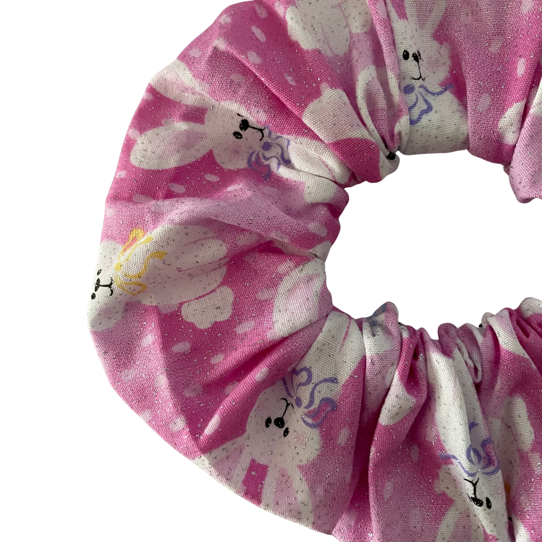 Scrunchie featuring white bunny pattern on a pink sparkle fabric.