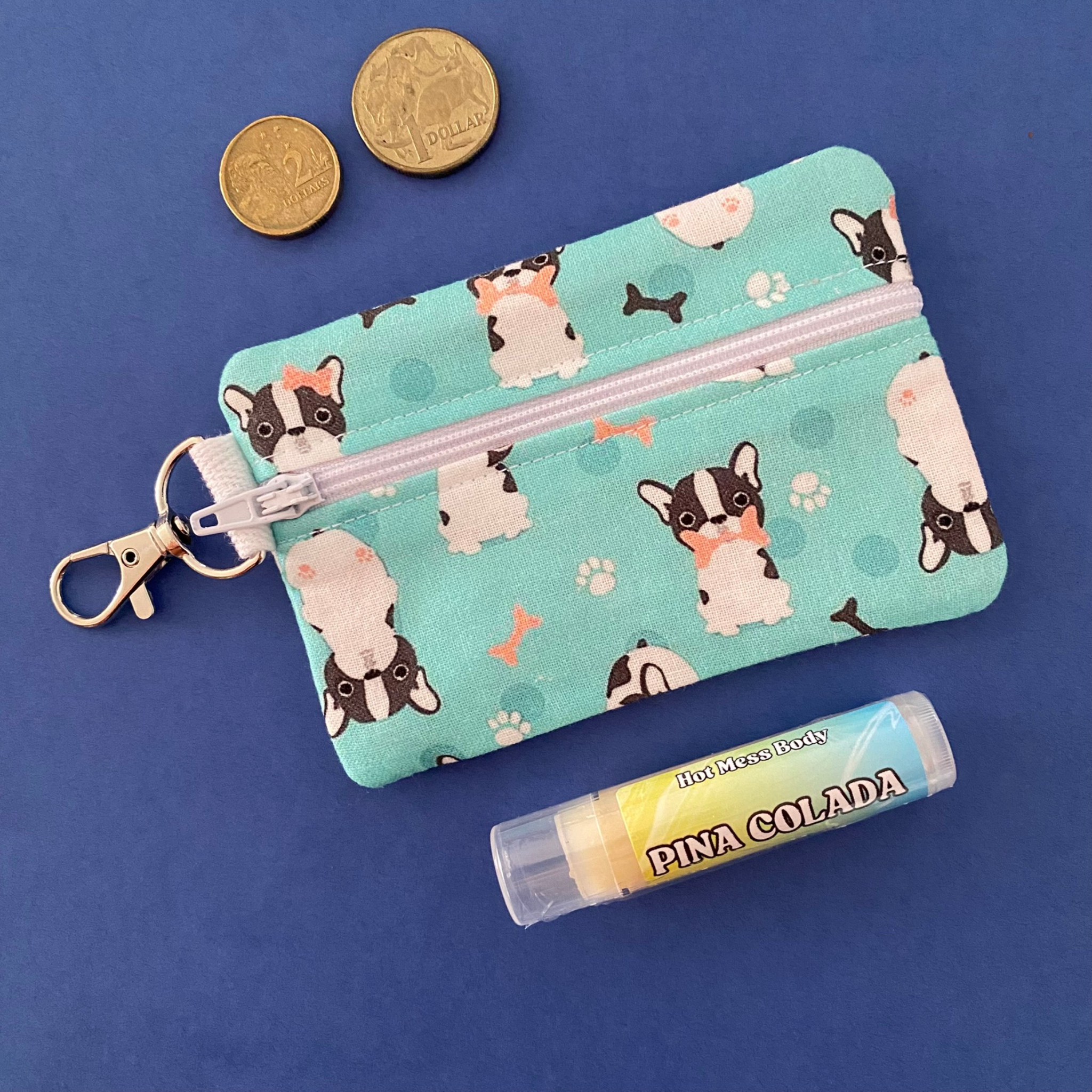 A clip coin purse with images of cute glasses and bow wearing french bulldogs on light blue fabric.