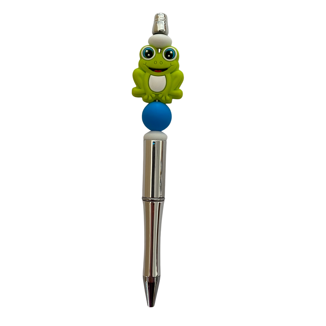 Pen with a frog silicone bead on top on a white background.