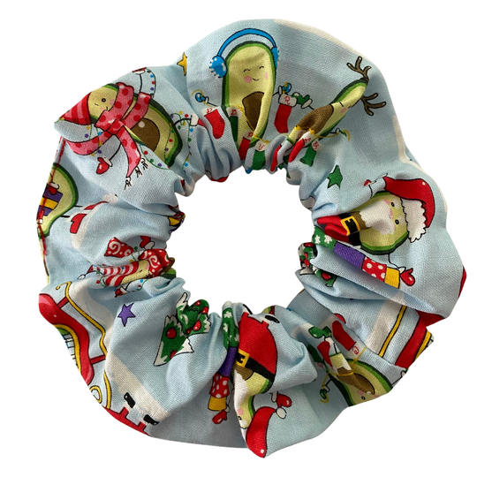 Playful images of avocados dressed in Christmas attire on a light blue fabric.