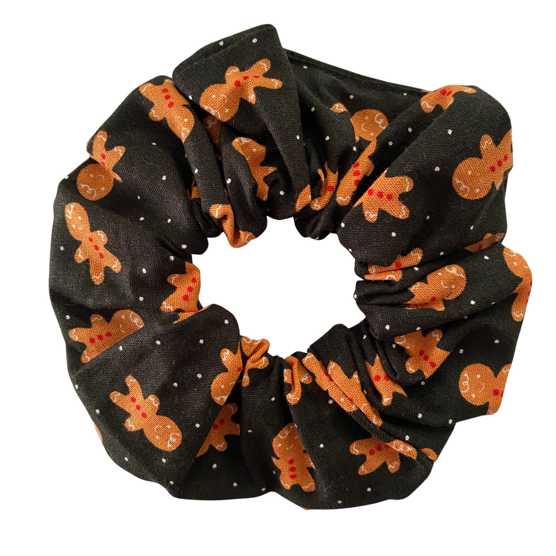 Black scrunchie with gingerbread man pattern on a white background.