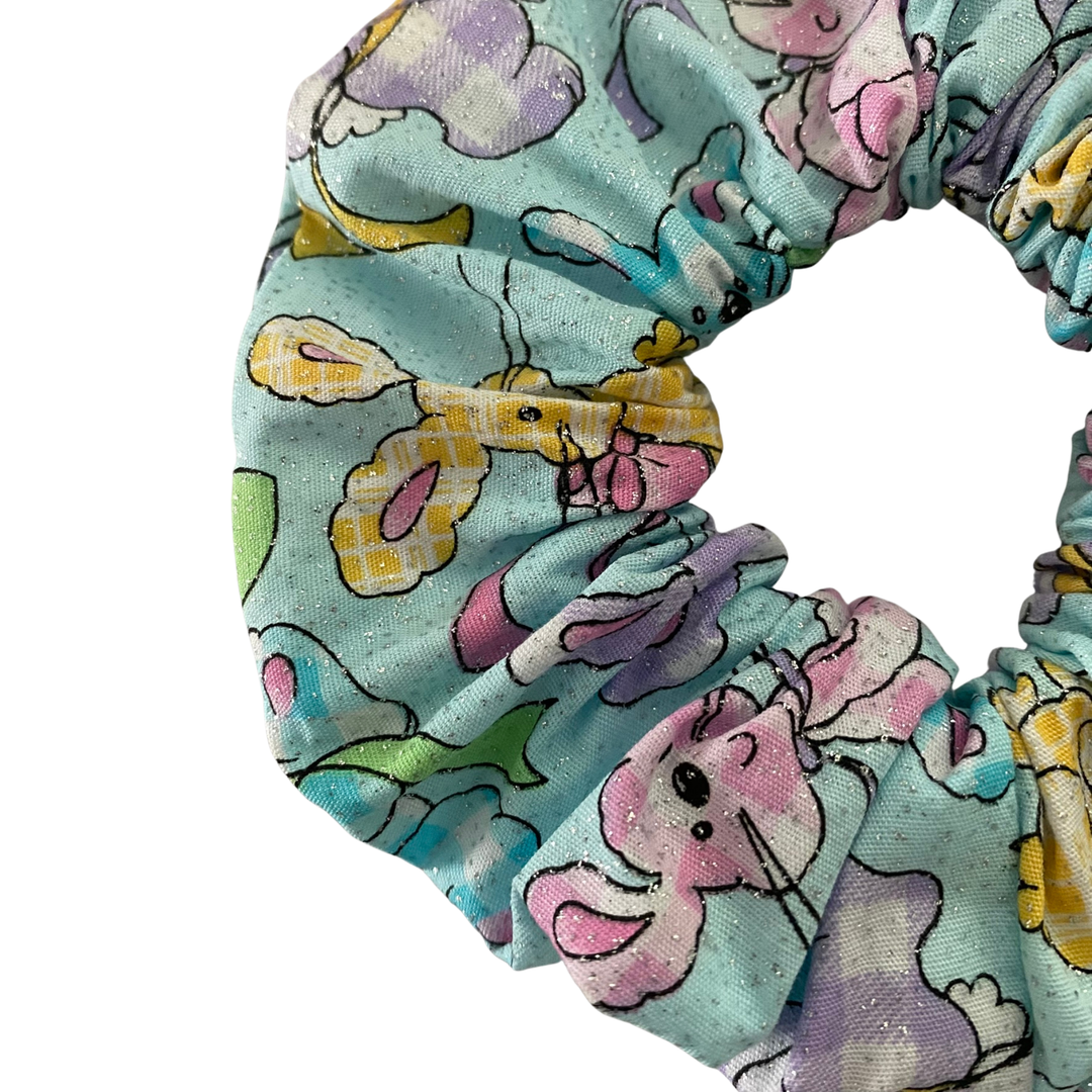 A blue and glitter scrunchie featuring pastel gingham bunnies.