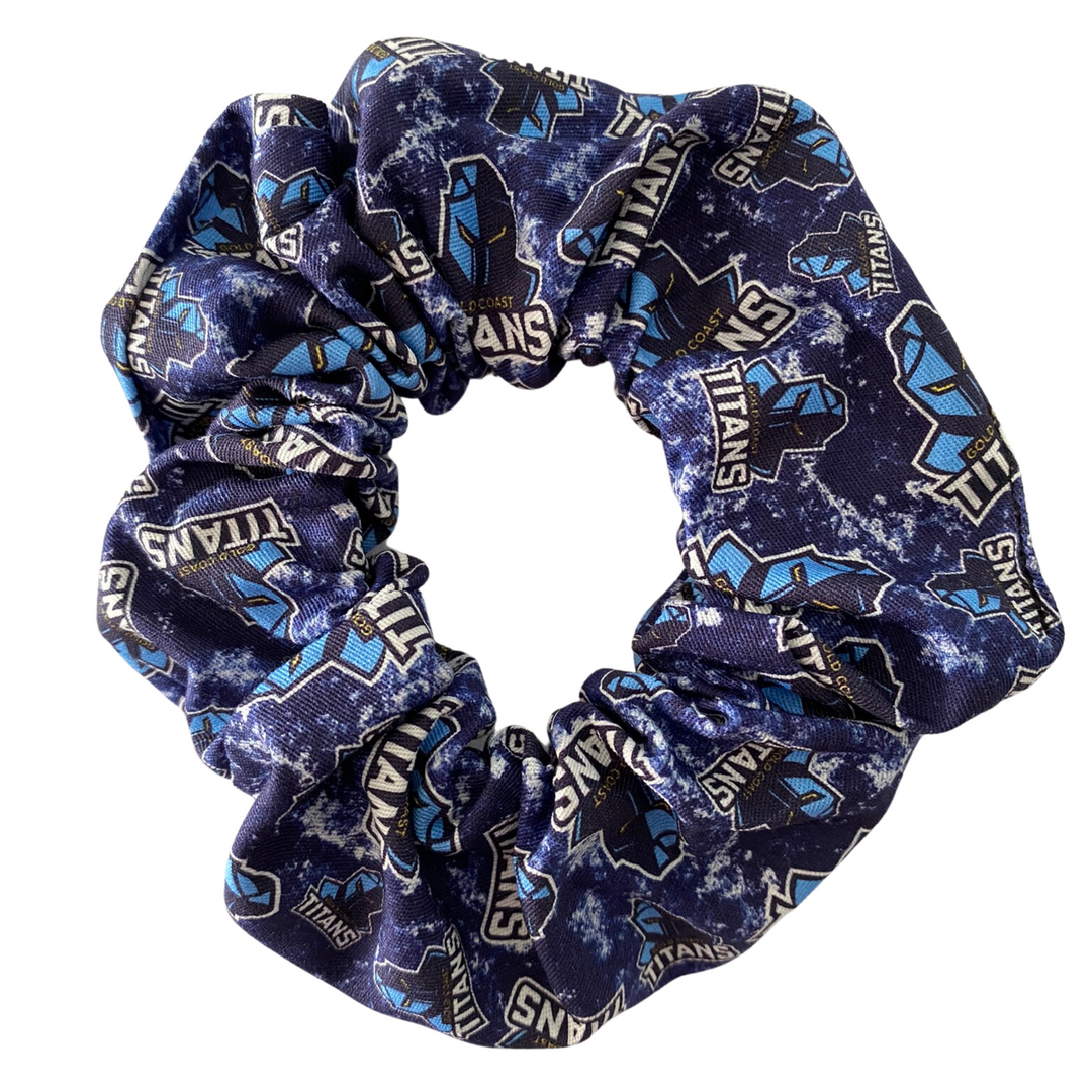 A scrunchie hair tie handmade with cotton woven fabric with images of the Gold Coast Titans rugby league team.