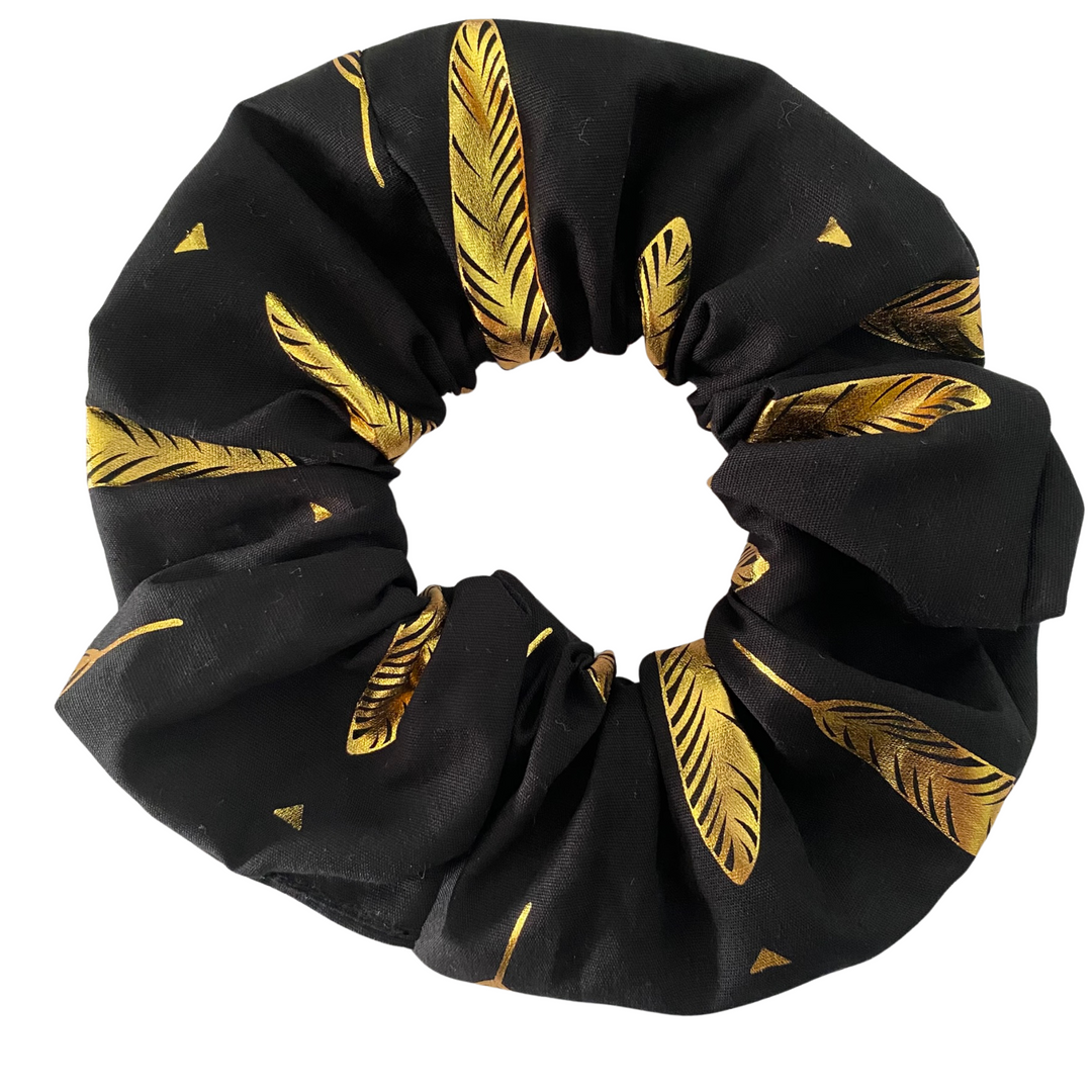 Gold Leaf Scrunchie handmade from black cotton fabric with metallic gold leaf patterns, featuring durable braided elastic for secure styling.