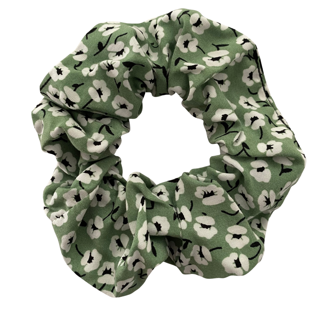 A green scrunchie with small white flowers.